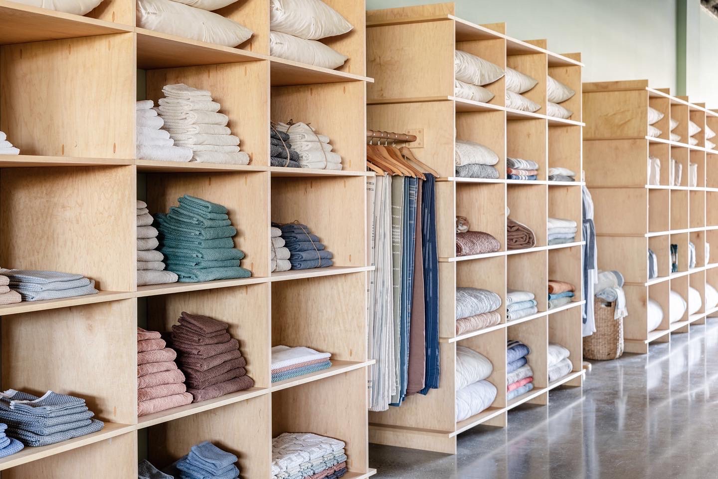 Birch plywood retail shelving filled with folded linens and bedding